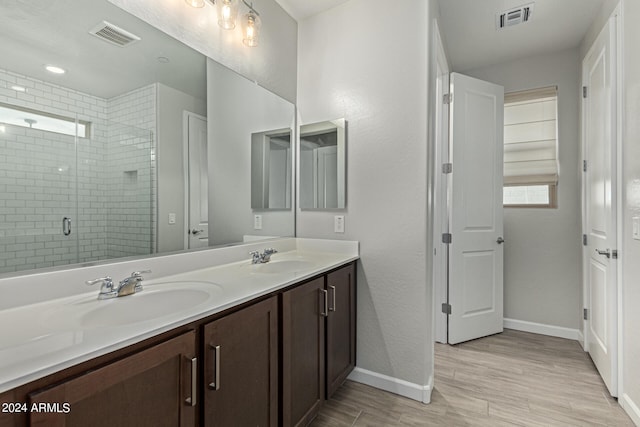 bathroom featuring double vanity, wood-type flooring, and a shower with shower door