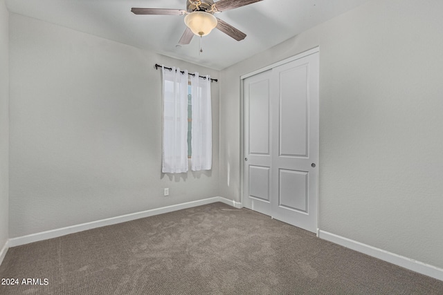 carpeted spare room with ceiling fan