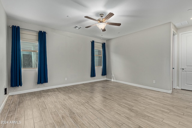 empty room with ceiling fan and light hardwood / wood-style floors