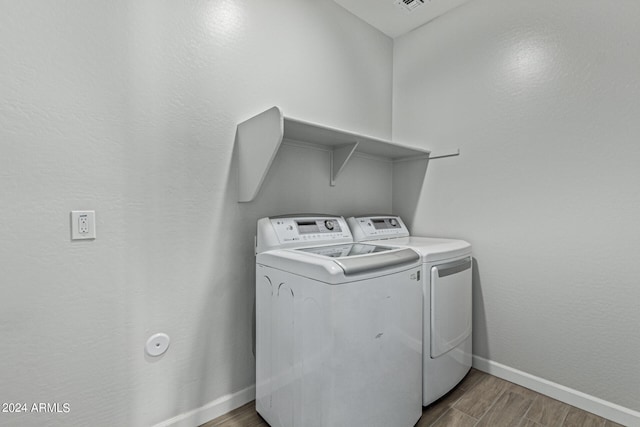 washroom with dark hardwood / wood-style flooring and separate washer and dryer