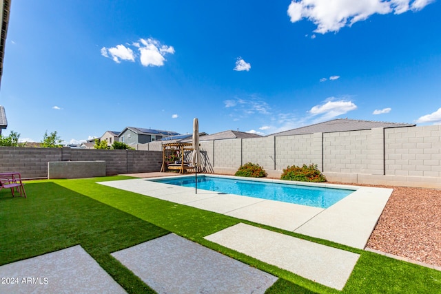 view of pool with a lawn and a patio