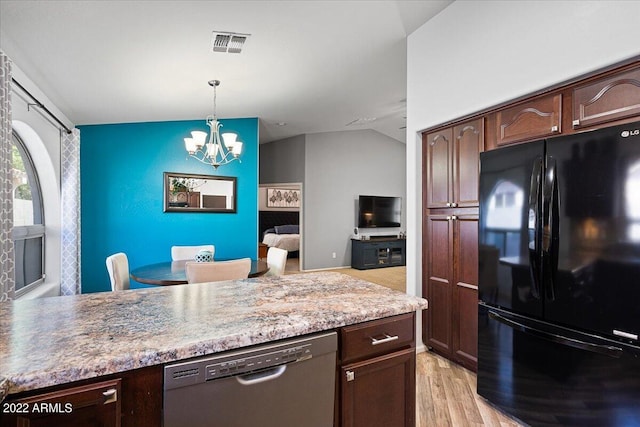 kitchen featuring light wood-type flooring, vaulted ceiling, stainless steel dishwasher, a notable chandelier, and black refrigerator