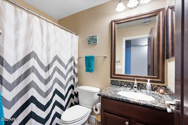 bathroom featuring vanity, toilet, and walk in shower