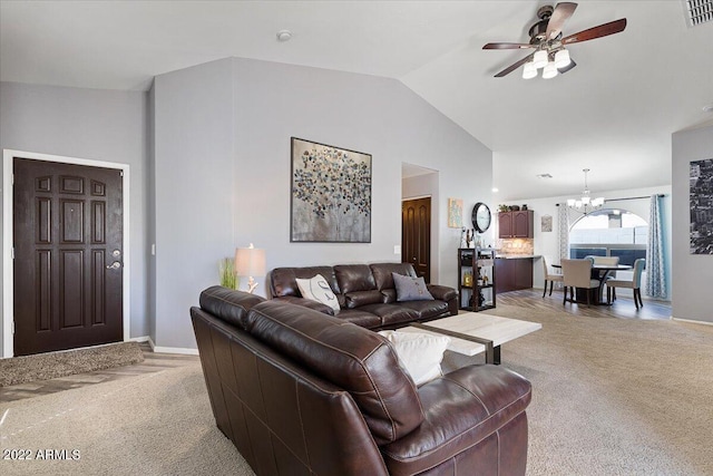 living room featuring light carpet, lofted ceiling, and ceiling fan with notable chandelier