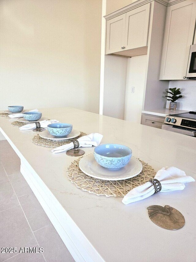 38167 W San Juan Ave, Tonopah, AZ 85354 - kitchen featuring stainless steel range with electric stovetop, light countertops, and tile patterned floors