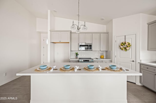 38167 W San Juan Ave, Tonopah, AZ 85354 - kitchen featuring stainless steel appliances, lofted ceiling, light tile patterned flooring, light countertops, and gray cabinetry