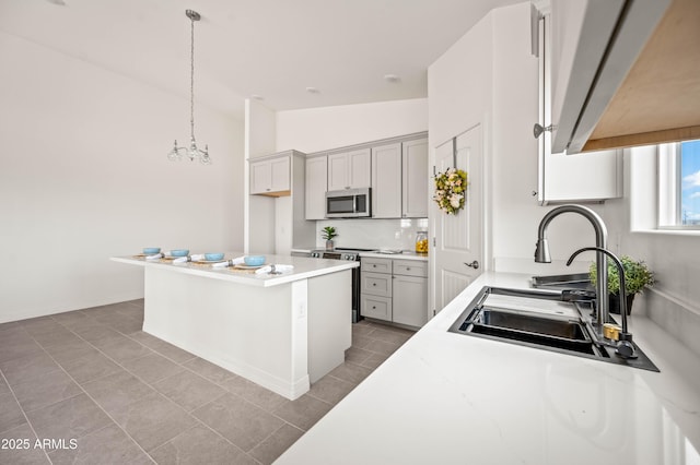38167 W San Juan Ave, Tonopah, AZ 85354 - kitchen featuring stainless steel appliances, a sink, light tile patterned floors, light countertops, and hanging light fixtures