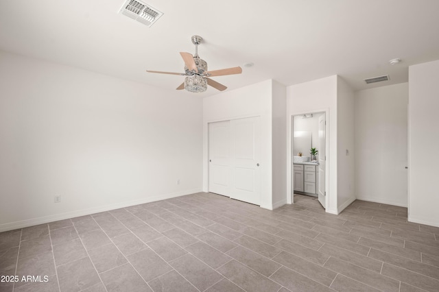 38167 W San Juan Ave, Tonopah, AZ 85354 - unfurnished bedroom with baseboards, ceiling fan, connected bathroom, and a closet