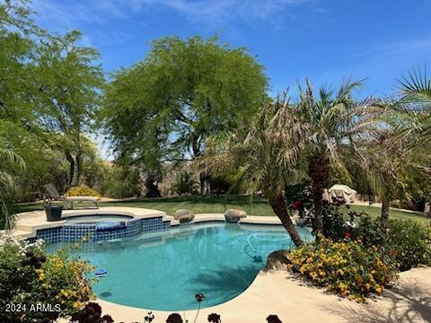 view of pool with an in ground hot tub