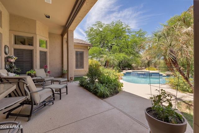 view of patio / terrace featuring a pool with hot tub