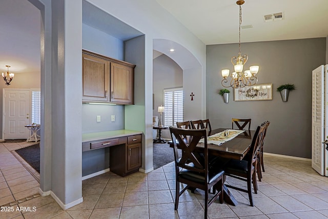 5049 E Duane Ln, Cave Creek, AZ 85331 - dining room featuring visible vents, arched walkways, light tile patterned floors, built in study area, and a notable chandelier