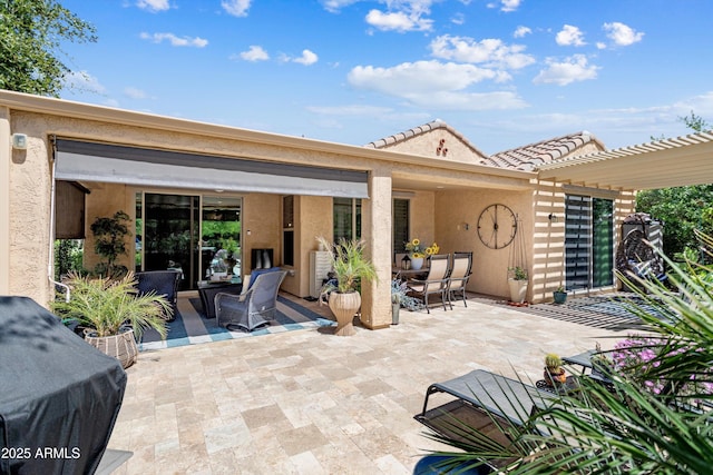 back of property featuring stucco siding, a patio, and outdoor dining space