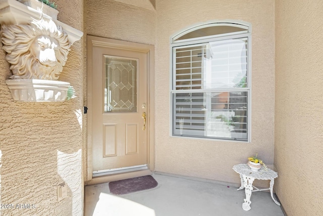 doorway to property featuring stucco siding