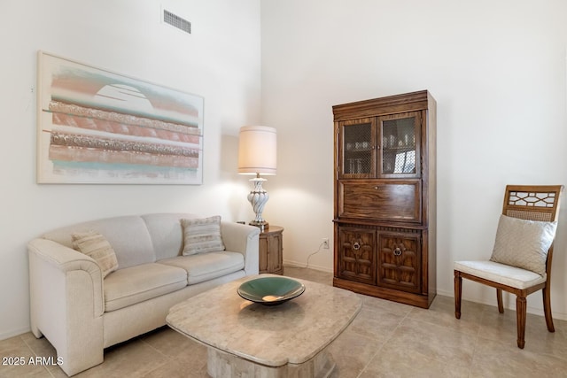 living area featuring visible vents, baseboards, and light tile patterned flooring