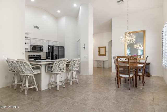 dining area featuring an inviting chandelier, a high ceiling, light tile patterned floors, and visible vents