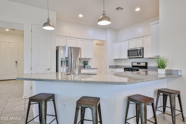 17082 S 182nd Ave, Goodyear, AZ 85338 - kitchen with stainless steel appliances, white cabinets, a breakfast bar, hanging light fixtures, and recessed lighting