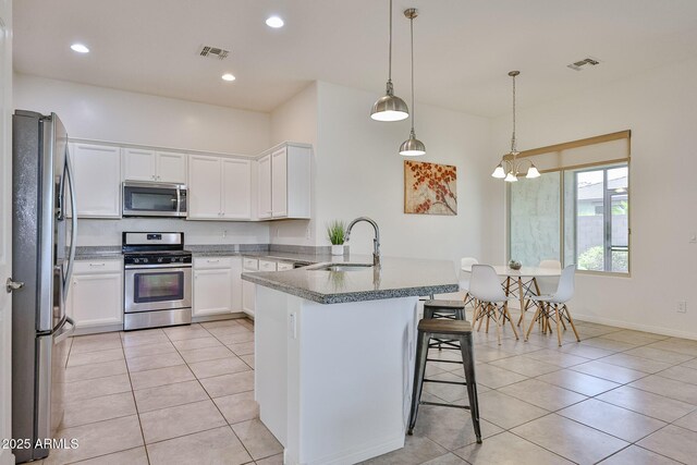 17082 S 182nd Ave, Goodyear, AZ 85338 - kitchen with appliances with stainless steel finishes, a peninsula, a kitchen breakfast bar, light tile patterned flooring, and white cabinets