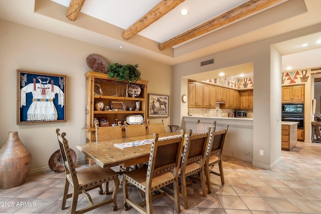 dining area with beamed ceiling and light tile patterned floors