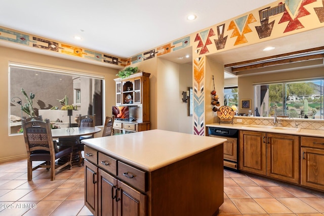 kitchen featuring light tile patterned floors, sink, dishwasher, a center island, and decorative backsplash