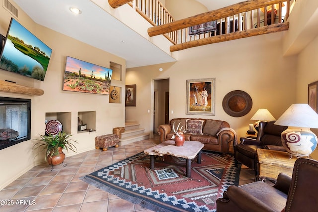 living room featuring a towering ceiling and tile patterned floors