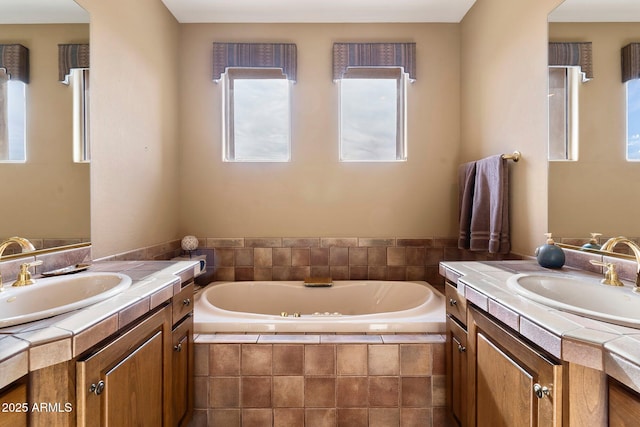 bathroom with vanity and a relaxing tiled tub