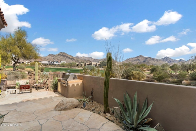 view of patio featuring area for grilling, a mountain view, and a grill