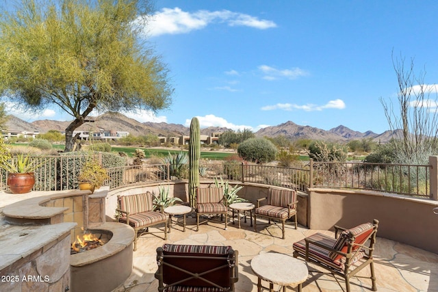 view of patio / terrace featuring a mountain view and an outdoor living space with a fire pit