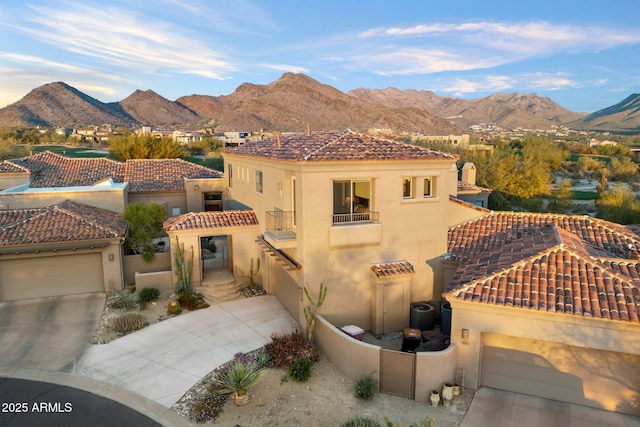 view of front of home with a garage, a balcony, and a mountain view