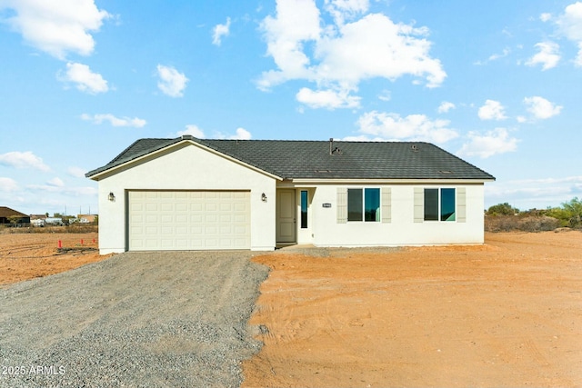 ranch-style house with driveway, an attached garage, and stucco siding