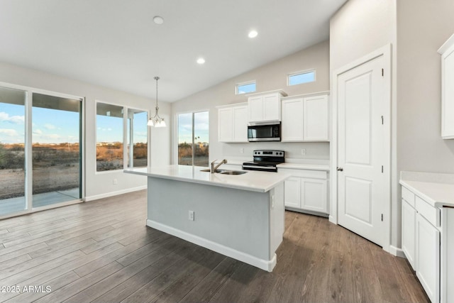 kitchen featuring a sink, stainless steel appliances, wood finished floors, and light countertops