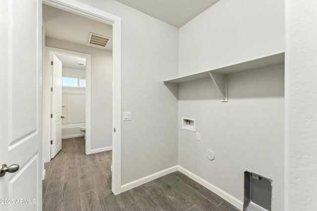 laundry area with laundry area, baseboards, visible vents, dark wood-type flooring, and hookup for a washing machine