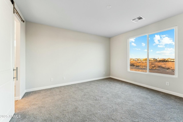 carpeted spare room featuring visible vents and baseboards