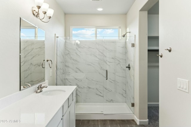 full bath with baseboards, plenty of natural light, vanity, and a marble finish shower