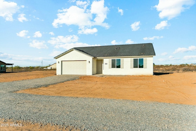 view of front of house with a garage, driveway, and stucco siding