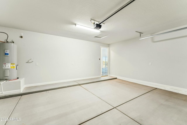 garage featuring baseboards, electric water heater, and a garage door opener