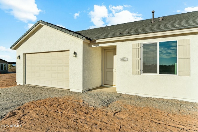 ranch-style home with an attached garage, driveway, roof with shingles, and stucco siding