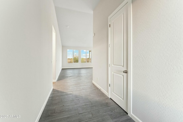 hallway with dark wood-style flooring and baseboards