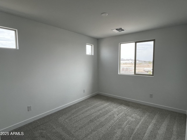 17481 W Fulton St, Goodyear, AZ 85338 - spare room with healthy amount of natural light, dark colored carpet, and baseboards