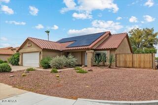 view of front of house featuring a garage and solar panels