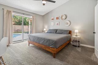 bedroom featuring ceiling fan, lofted ceiling, dark carpet, and access to outside