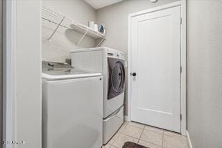 clothes washing area with separate washer and dryer and light tile patterned floors