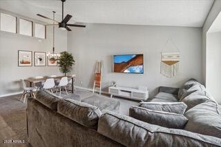 carpeted living room with ceiling fan