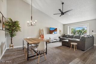 dining space featuring high vaulted ceiling, dark hardwood / wood-style flooring, and ceiling fan with notable chandelier