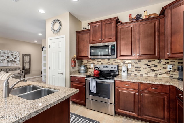 kitchen featuring decorative backsplash, recessed lighting, light wood-style floors, stainless steel appliances, and a sink