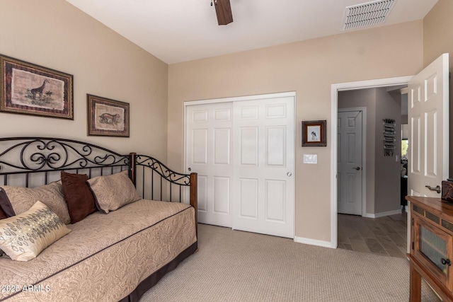 bedroom featuring visible vents, a ceiling fan, a closet, baseboards, and light colored carpet