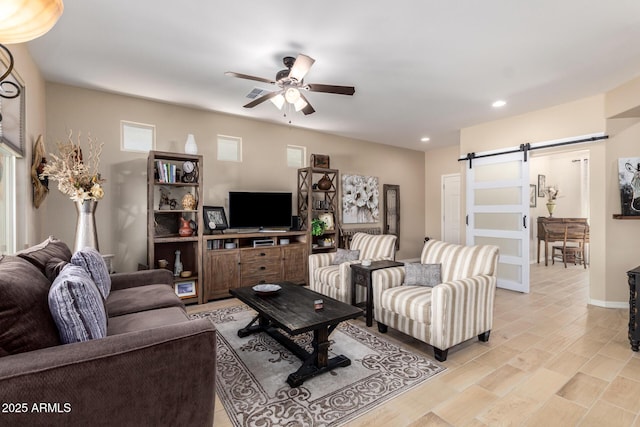 living area featuring visible vents, a ceiling fan, recessed lighting, a barn door, and baseboards