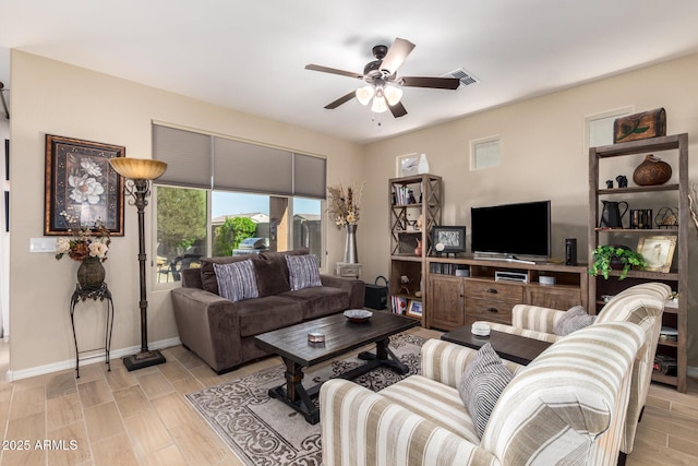 living room featuring light wood-type flooring, baseboards, visible vents, and ceiling fan