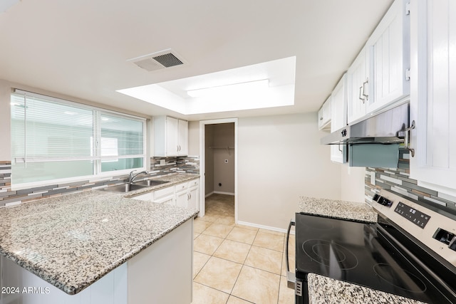 kitchen with sink, stainless steel range, decorative backsplash, and white cabinets