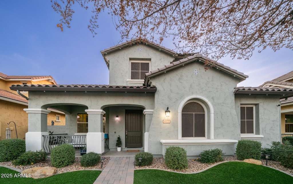 mediterranean / spanish home with a porch