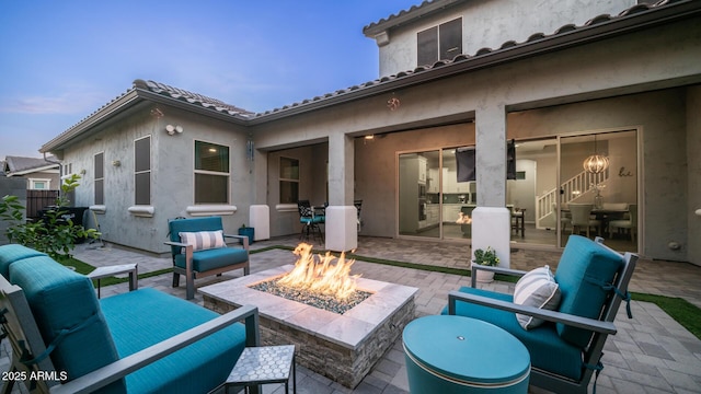 view of patio with an outdoor living space with a fire pit